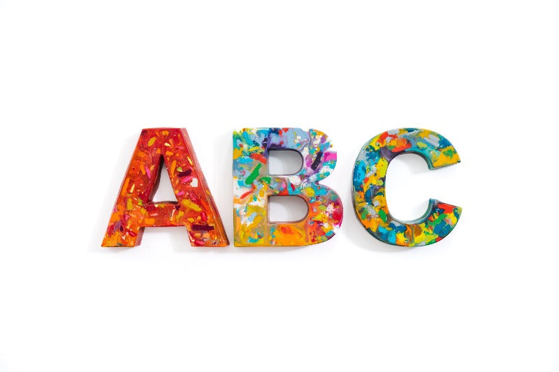 Rainbow crayon letters that are giant crayons for a unique teacher appreciation gift or graduation gift. Image is of oversized crayon letters in the shape of an A, B, and C on a white background.
