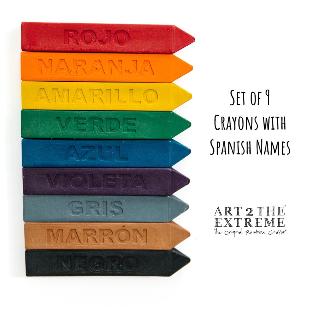 9 solid colored crayons on a white background. Rojo, naranja, Amarillo, verde, Azul, Violeta, gris, marron, and negro are engraved on each crayon to learn the Spanish colors.