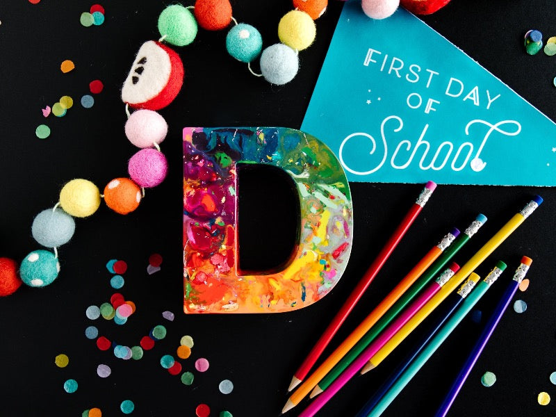 Oversized crayons in the shape of giant letters. This is a giant letter D that has rainbow colors in ROYGBIV order. First day of school gift for kids or teacher gift idea.