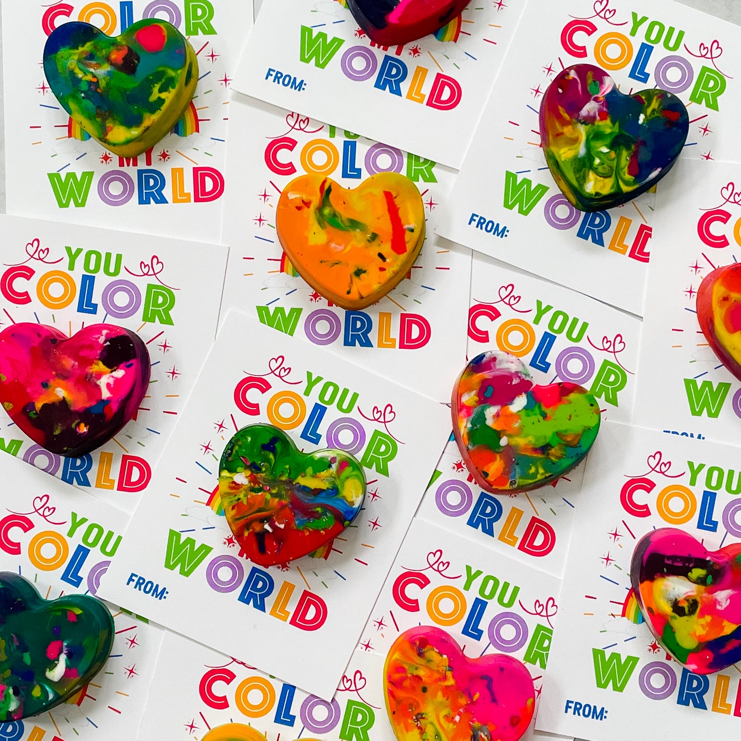 9 colorful heart crayons, each on white "You Color My World" printable valentines for classmates.