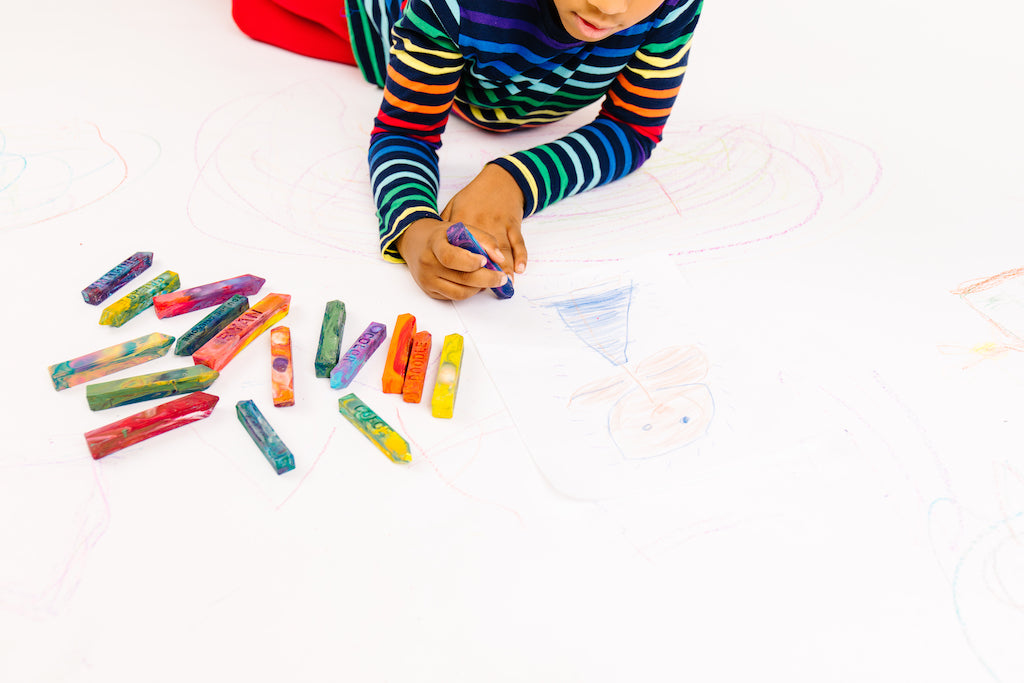 Kid is coloring with a multicolored Crayon Stix from crayon shop Art 2 the Extreme. The entire image is white and the child is cooling directly on the ground with 16 other crayon sticks on the white ground. This is not paint. See the sellers website or more information about crayon size and small parts.