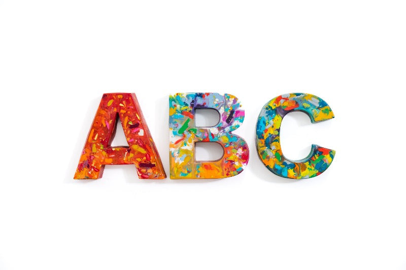 Rainbow crayon letters that are giant crayons for a unique teacher appreciation gift or graduation gift. Image is of oversized crayon letters in the shape of an A, B, and C on a white background. 