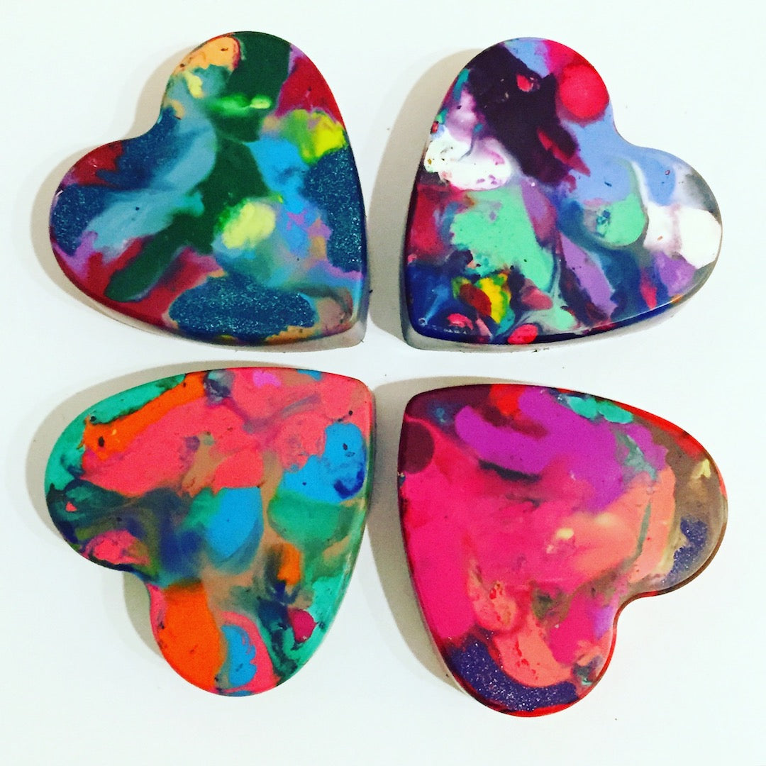 Four jumbo crayons in the shape of hearts on a white background.  Heart shaped crayon melting art gift from Art 2 the Extreme. 