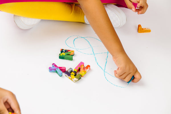 Child holding a crayon letter